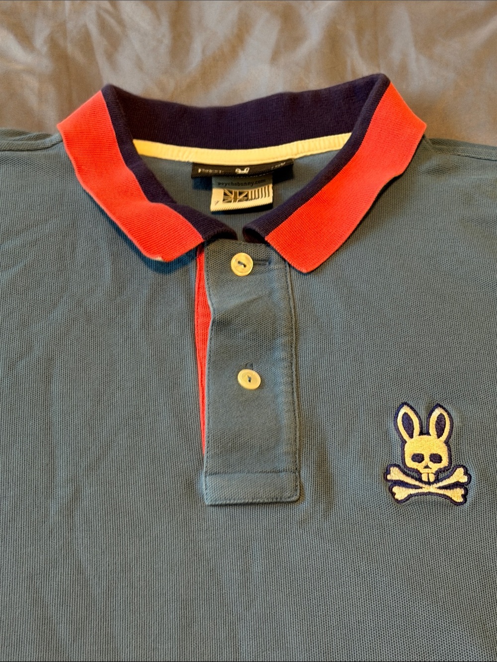 Psycho Bunny  Slate Blue Polo with Navy and Orange Trim